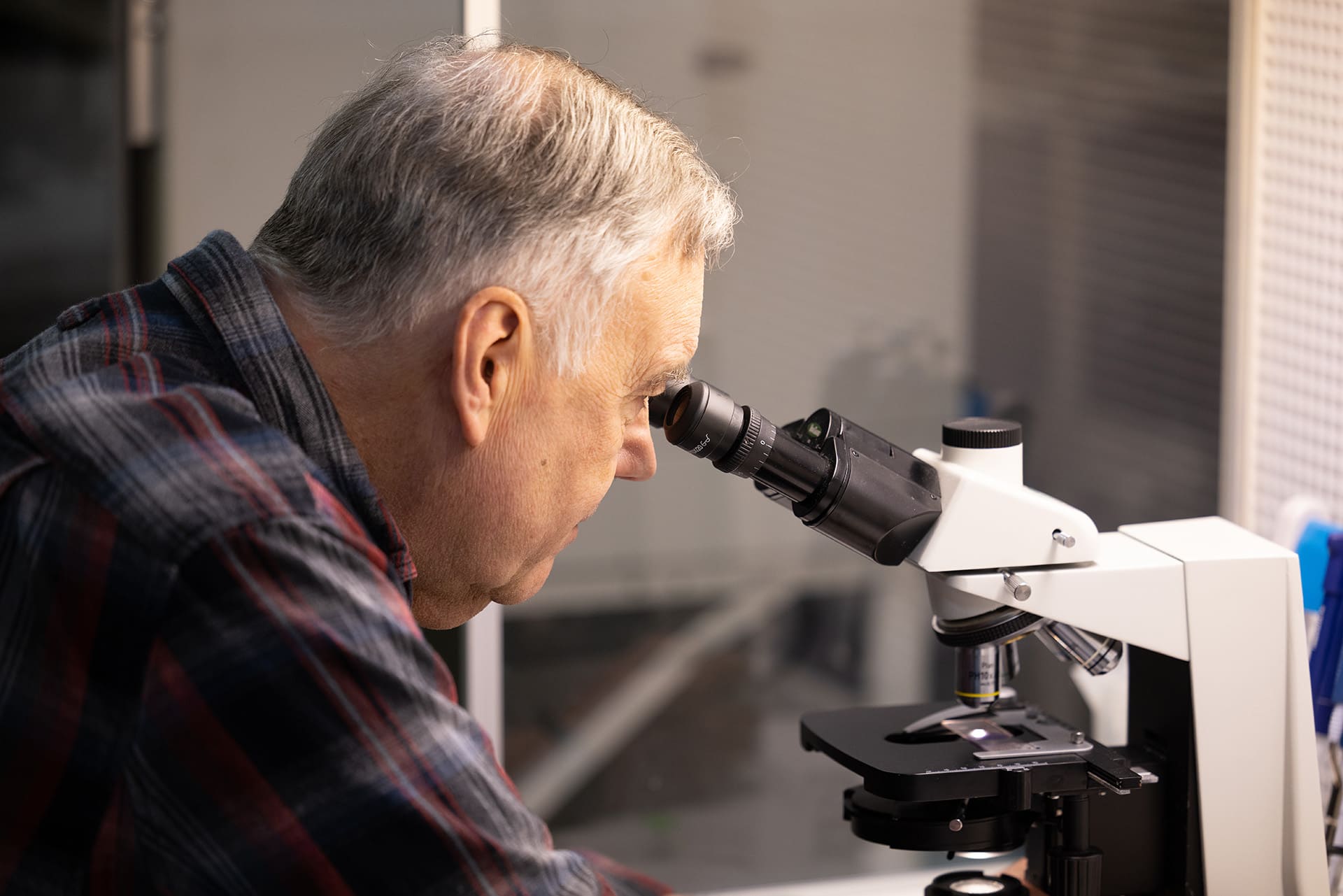 man looking through microscope